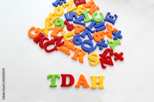 Colored toy letters for children form the word TDAH which means Attention Deficit Hyperactivity Disorder in Spanish that occurs with inattention, hyperactivity and impulsivity