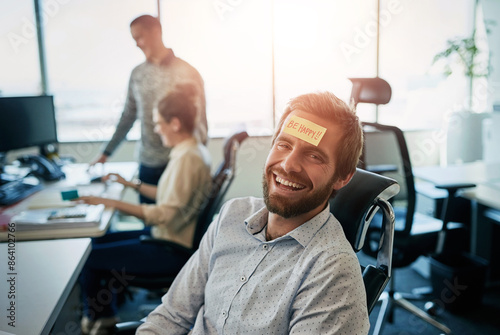 Man, portrait and paper on forehead in office with happy reminder, work break and comedy prank by desk. Business worker, guy laughing and sticky note on face with smile, funny and workplace humor