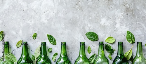 Green glass bottles and fresh leaves in a zero waste concept with copy space image.