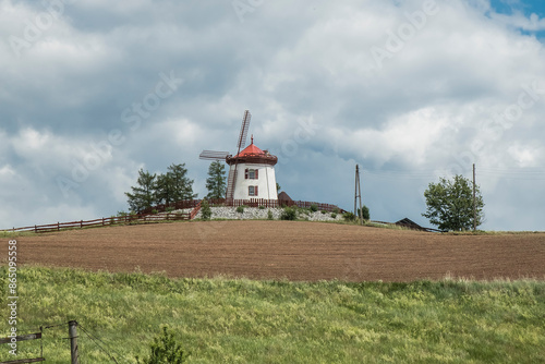 odrestaurowany wiatrak typu holender na tle bezchmurnego nieba