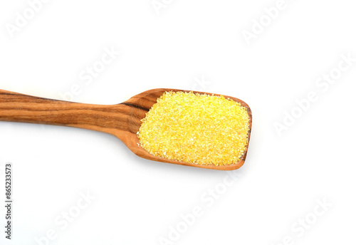 Uncooked cornmeal maize flour heap in a spoon isolated on white background