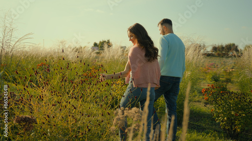 Romantic honeymoon. Happy family loving married Caucasian couple male husband man female wife woman holding hands stroll walking talk planning future together enjoying nature farmland field vacation