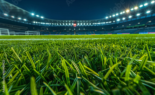 A close-up view of a well-lit soccer field at night, focusing on the grass.