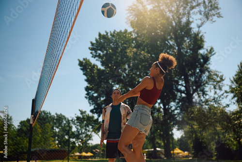 Below view of woman playing beach volleyball with friends.