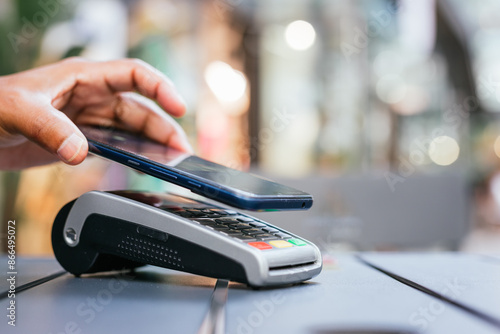 man paying contactless with mobile phone in restaurant.