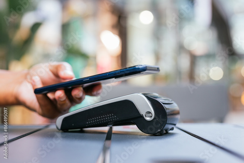 man paying contactless with mobile phone in restaurant.