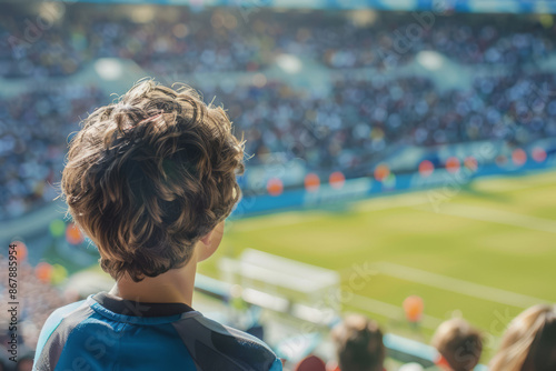 Boy watching a soccer game in a crowded stadium