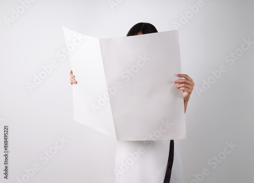 Woman reading mockup of blank newspapers to add your own news isolated on white background.