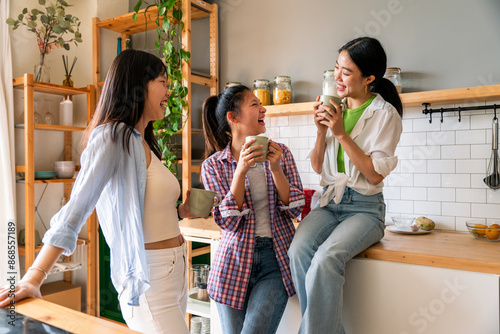 Happy beautiful chinese women friends bonding at home