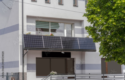 Słoneczna „elektrownia” na balkonie, fotowoltaika w mieście. Panel fotowoltaiczny wytwarzający prąd, zainstalowany na balkonie zabytkowej kamienicy miejskiej.