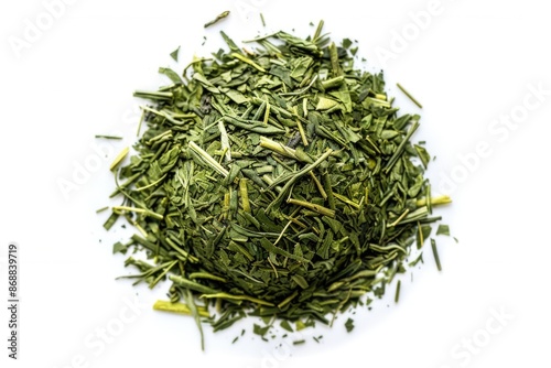 A pile of green tea leaves on a white surface