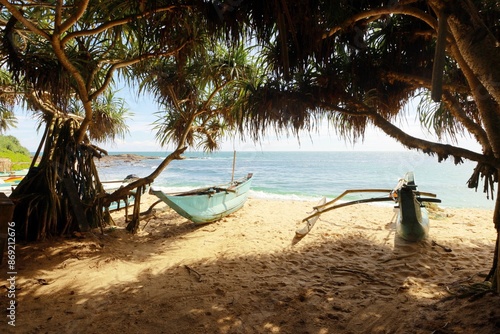 Authentic traditional Sri Lankan fishing boats on the tropical beach in the jungle