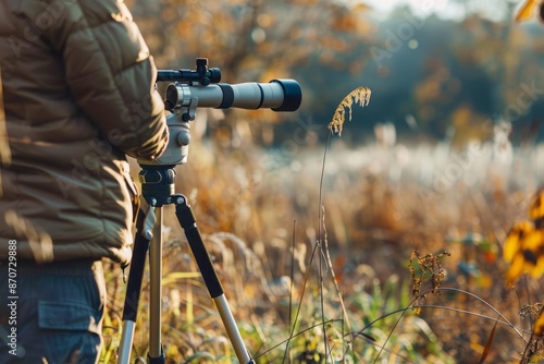 A person setting up a spotting scope on a tripod in a nature reserve with a focus on the detailed equipment used for birdwatching