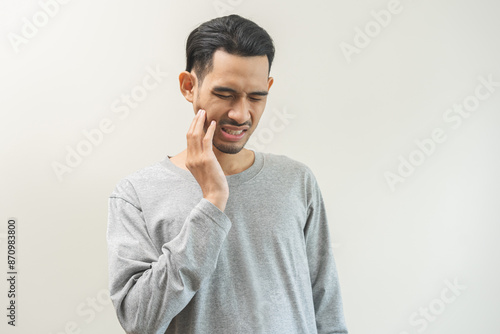 Portrait of male face suffering from sensitive teeth, tooth pain asian young man feeling hurt hand touching cheek and mouth. Health care, medicine of toothache. Dental decay problem, dentist treatment