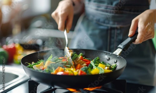 close up of hands cooking vegetables in a wok on a stove at home, using fork and spoon, colorful vegetable mix, healthy breakfast, high quality photo, blurred background