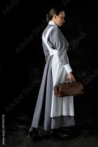 World War 1 nurse wearing a grey dress and white apron