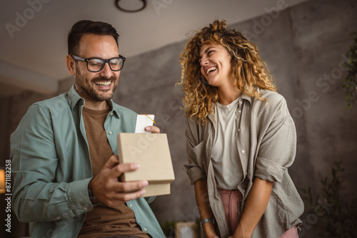 Surprised boyfriend hold gift read greeting card from his girlfriend