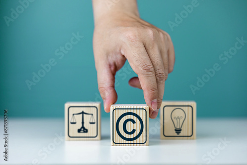 Copyright symbol or intellectual property rights of patentee on wooden cube. Business concept of author rights, designer, and trademark license