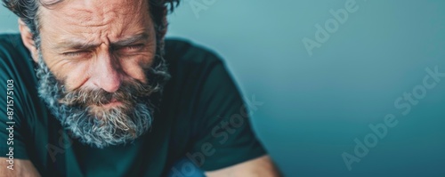 Portrait of Disgusted Bearded Man with Wrinkled Nose and Downturned Mouth in Stark Lighting, Copy Space Below