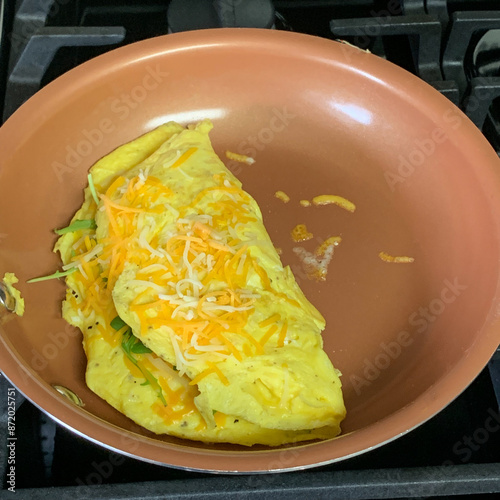 An omelet cooking on a skillet.