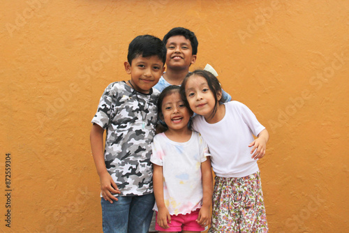 Two happy and excited dark-skinned Latino boys and 2 girls celebrate Children's Day by playing and laughing