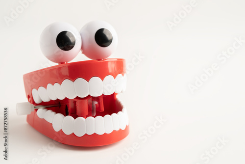 Tooth funny toy denture red color jaw and eye on whtie background.