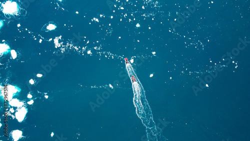 Motorboat in the Southern Ocean, Antarctica. Little boat in the big Ocean. Track from the boat in the frozen ocean