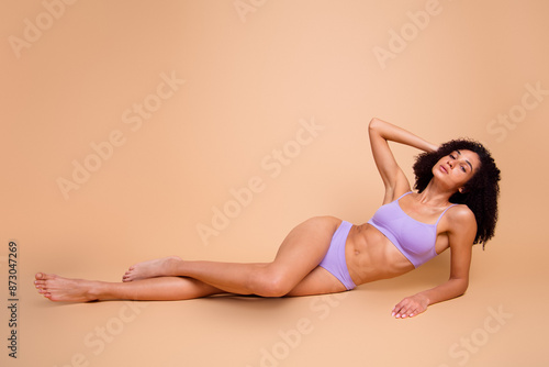 Full body no filter portrait of stunning model girl posing studio floor isolated on beige color background