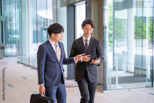 歩きながら打ち合わせをする男性ビジネスマン