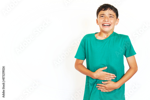 preadolescent boy with freckles touching his abdomen with a gesture of pain and suffering