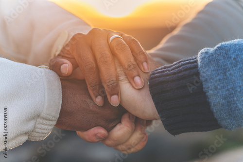 Diverse Hands Clasped Together at Sunset