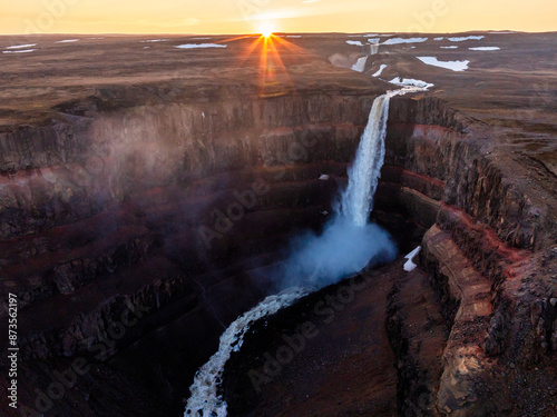 Aerial view on Hengifoss waterfall with red stripes sediments and old soil volcanic formation in Iceland.