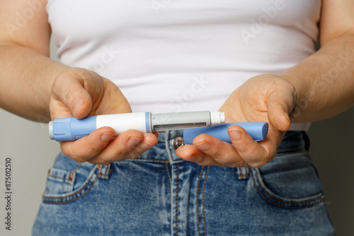 Diabetes blue Insulin or Semaglutide Injection pen closeup. Semaglutide or insulin drug against female belly. Semaglutide, Diabetes and Weight Loss concept.