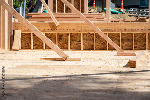 Wood framing started on new home construction job site, exterior walls with windows and subfloor 