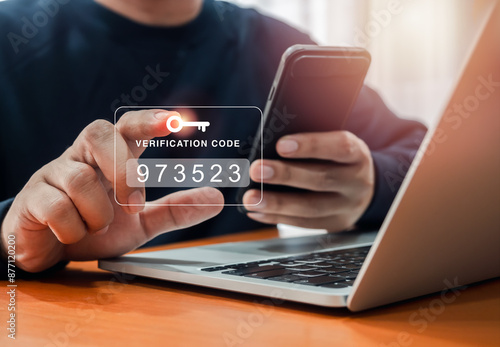 Two factor authentication or 2FA concept. Verification code with key icon press by man hand while using smart phone and laptop computer for validate password, secure steps, cyber security technology.