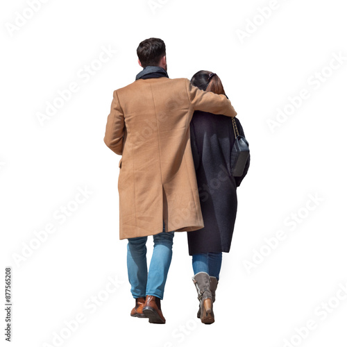 Jeune couple vu de dos qui se promène en amoureux l'un à coté de l'autre, ils sont chaudement habillés, il y a du soleil.