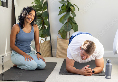 Exercising together, couple doing yoga on mats with water bottle nearby