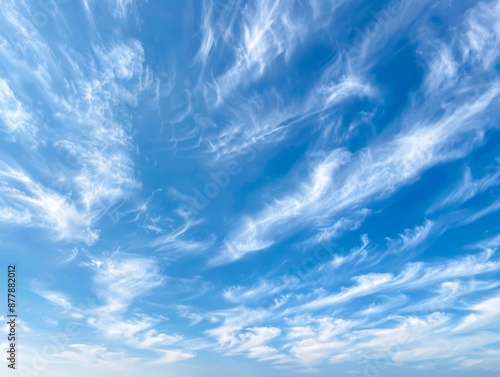 2. Serene scene with layers of feathery cirrus clouds gliding in opposite directions against a vibrant blue sky, creating a dynamic yet tranquil skyscape