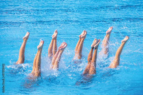 Artistic swimming team performing synchronized legs movement in swimming pool