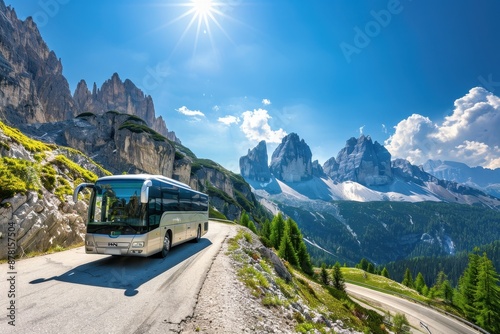 A travel agency bus traveling on a scenic dolomites mountain road with stunning peaks and a bright blue sky.