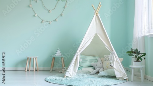 White teepee tent in a light green child's room with a plush toy