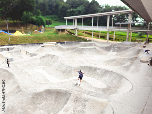 At a public skatepark in Taman Cabaran, Putrajaya, people are working on a trick.