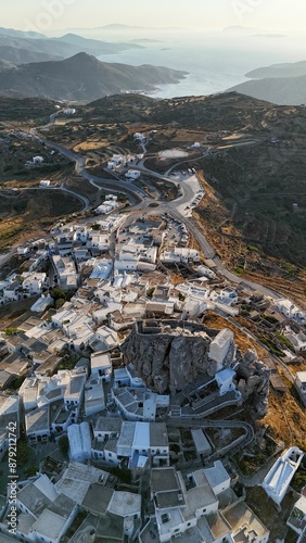 Aerial view of a picturesque village with white houses on a mountain, overlooking the sea.