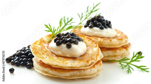 Two blinis topped with caviar and sour cream, garnished with dill.