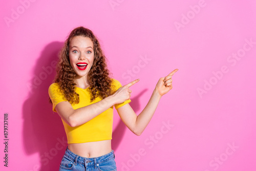 Photo of shiny attractive lady dressed yellow t-shirt pointing two fingers empty space isolated pink color background