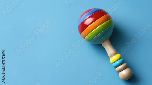 Vibrant baby rattle on a blue backdrop with space for text