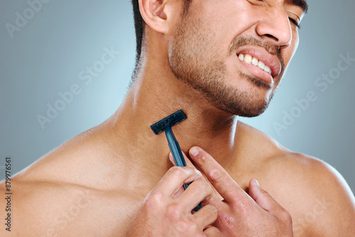 Frustrated man, hands and shaving neck with razor blade for grooming, skincare or irritation on a blue studio background. Closeup, male person or young model with tool for hair removal in discomfort