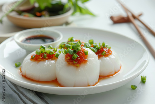 a plate of scallops with sauce and green onions