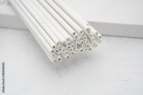 White electrodes with copper tips for TIG/MIG welding applications in industrial and professional settings on a white background, welding rods for industrial use in close up.