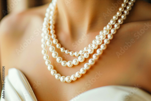 Elegant pearl necklace draped around the neck of a woman in a ball gown, with luminous pearls gleaming against her skin and adding a touch of sophistication to her ensemble